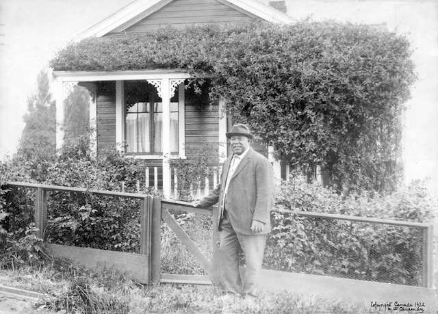 乔在比德威尔街（Beach Avenue 1700）脚下的小屋前的小屋前。照片于1922年复制。温哥华档案＃CVA 371-1977。